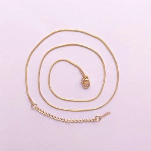 Detail of gold snake chain necklace with lobster clasp and adjustable extender