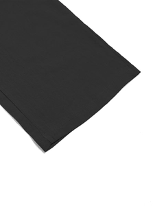Detail shot of black woven fabric showing high-quality stitching on cuff or hem