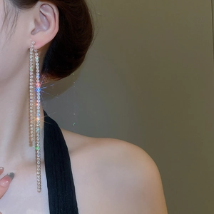 Close-up of sparkling long tassel earrings with silver finish and zircon rhinestones
