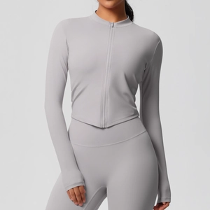 Détail d'un ensemble de yoga gris clair ajusté avec tissu sans couture et col montant zippé
