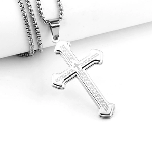 Macro detail of silver stainless steel cross pendant with engraved Lord's Prayer text