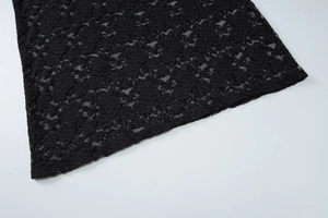 Gros plan sur la dentelle noire aux motifs floraux délicats et texture ajourée
