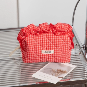 Red and white checkered quilted cosmetic bag with ruffled edges and zipper closure