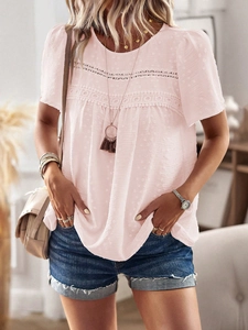 Close-up of pink crew neck top featuring lace patchwork and textured polka dot fabric