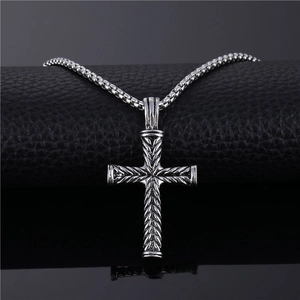 Vintage silver cross pendant necklace for men with textured details on a black roll