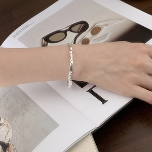Close-up of S925 sterling silver hammered bangle with irregular wavy texture on wrist