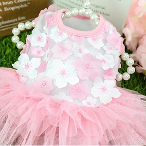 Pink floral mesh pet dress with 3D appliques displayed on a garden-style grass background