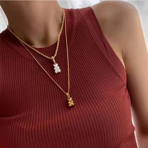 Dettaglio di una collana a due strati in oro con ciondoli a forma di orso e perle