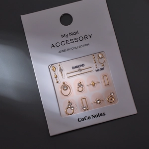 Detail of luxury 3D nail art jewelry set featuring gold metal shapes and rhinestones