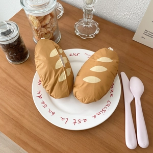 French baguette style foldable shopping bags set in a decorative ceramic plate