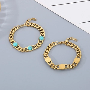 Close-up of gold Cuban link bracelets with turquoise stones on a minimalist background