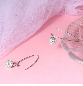 Macro shot of silver S925 pave-set crystal ball earrings on elegant decorative background