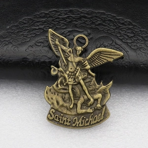 Close-up of bronze metal pendant featuring Saint Michael slaying the dragon detail