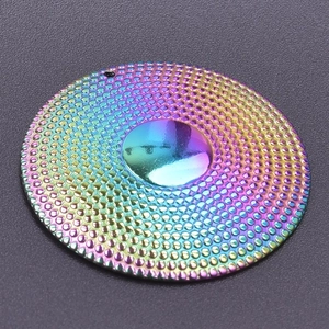 Macro shot of iridescent rainbow round metal pendant with textured surface for DIY jewelry