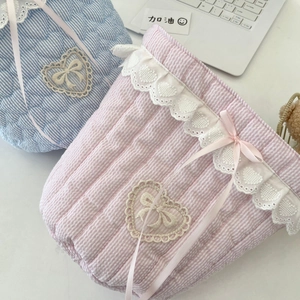 Detail of quilted cotton fabric storage bags with lace trim and heart shaped patches