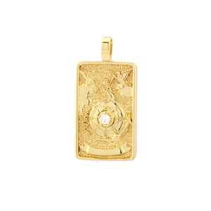 Macro shot of gold-plated tarot pendant featuring intricate relief and white cubic zirconia