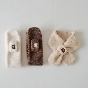 Detailed view of plush cross-through scarves in white, brown and beige with bear embroidery