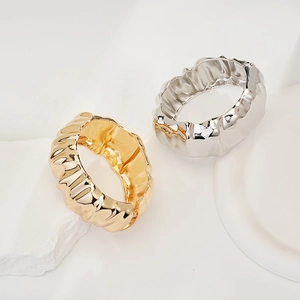 Detailed view of gold and silver rings with unique irregular lava-like metal texture