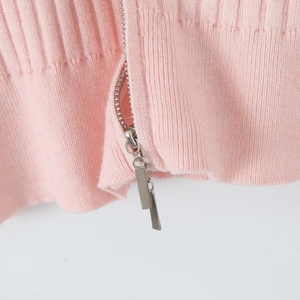 Vue détaillée du tricot côtelé rose avec double fermeture éclair en métal argenté