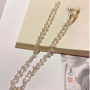 Detail of faceted crystal beaded chain with gold links and adjustable rubber loops