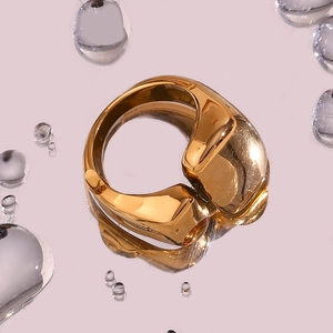 Vue détaillée d'une bague géométrique épaisse plaquée or 18 carats sur surface réfléchissante