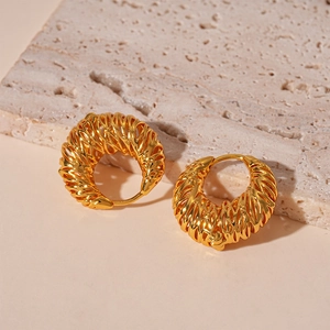 Golden hollow woven C-shaped earrings with a metallic texture on a natural stone base