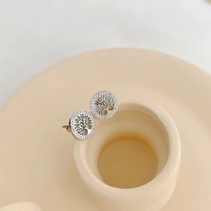 Detailed close-up of silver tree of life earrings with sparkling crystal accents