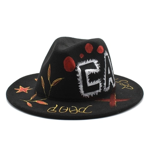 Détail du chapeau en laine noire avec graffiti peint à la main et motifs d'étoiles