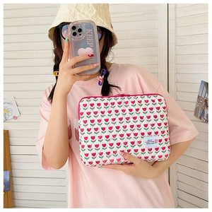 Quilted floral laptop sleeve with tulip pattern and pink zipper held by a model