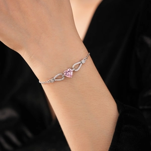 Close-up of pink heart-shaped zircon bracelet with silver pavé crystals on a wrist