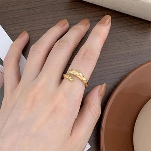Detailed close-up of 925 silver irregular gold ring with three sparkling zircons on hand