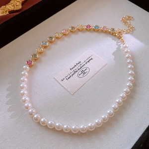 Close-up of pearl and crystal necklace on a vintage tray with French Paris quote card