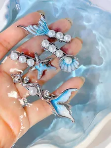Detail of ocean-themed hair clip set with blue enamel fish tail, starfish, and pearls