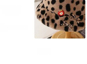 Detail of leopard print plush bucket hat with red apple buckle and bow decoration