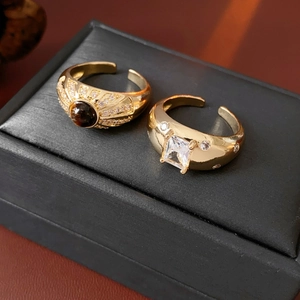Detail von Vintage Goldringen mit Tigerauge und Zirkonia auf schwarzer Schmuckschatulle