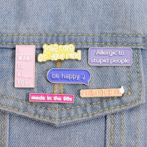Set of colorful enamel lapel pins with creative text on light blue denim jacket pocket