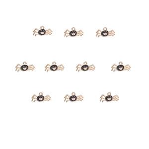Detail of ten golden spider charms with black and white enamel smileys for DIY jewelry