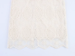 Dettaglio in pizzo beige elegante con motivi floreali geometrici e bordi a ventaglio