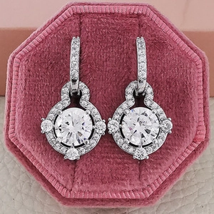 Detailed macro of silver stud earrings with clear round zircon in a pink velvet box