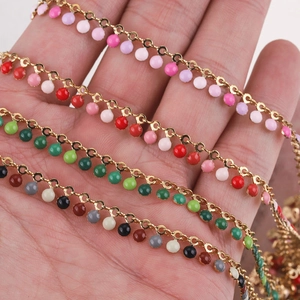 Detailed close-up of colorful enamel beads on gold-plated stainless steel chains