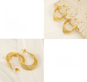 Detailed view of polished 18k gold earrings with layered geometric texture and fine finish