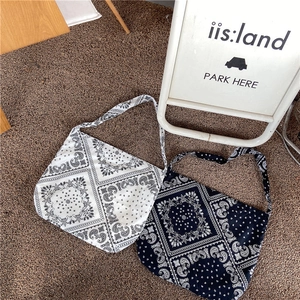 Detail of bohemian paisley print on large black and white canvas shoulder bag outdoors