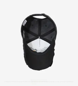Interior detail of black cotton baseball cap showing sweatband and 100% cotton label