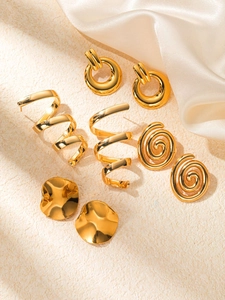 Détail d'un ensemble de boucles d'oreilles en acier titane doré sur soie
