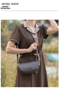 Detailed view of printed saddle bag with pearl pendant worn by model outdoors