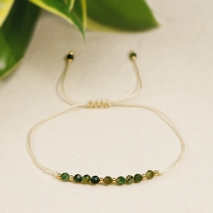 Bracciale fatto a mano con pietre verdi, perline dorate e cordino crema regolabile