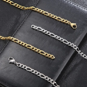 Close-up of gold and silver titanium steel Figaro chain necklaces with lobster clasps