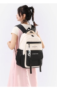 Vue latérale du grand sac à dos noir et blanc sur modèle avec détail de pendentif étoile