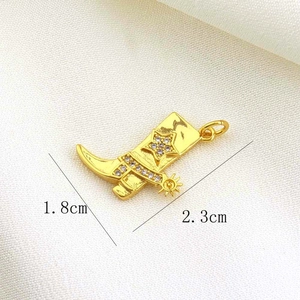 Detailed macro view of golden cowboy boot pendant with sparkling rhinestones and size info