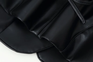 Détail de la texture du cuir PU noir de qualité supérieure et coutures précises de la veste